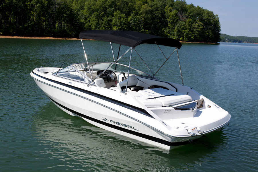 White surf boat floating on a lake.